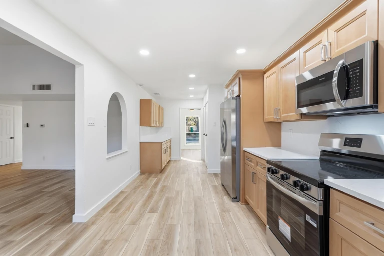 Kitchen remodel with wood flooring and arched opening